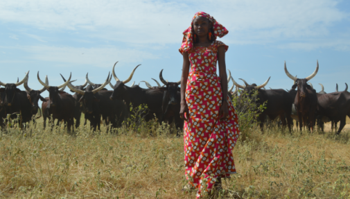 Indigenous woman Hindou Omar of Chad standing in front of cattle