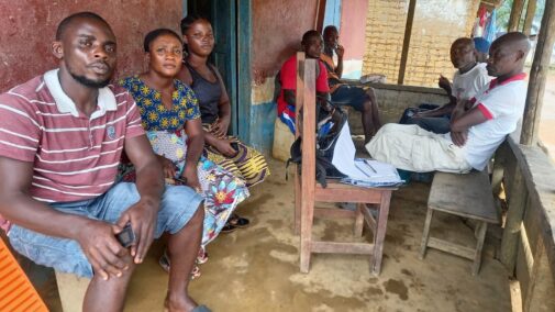 Men and women sitting in rural Liberia