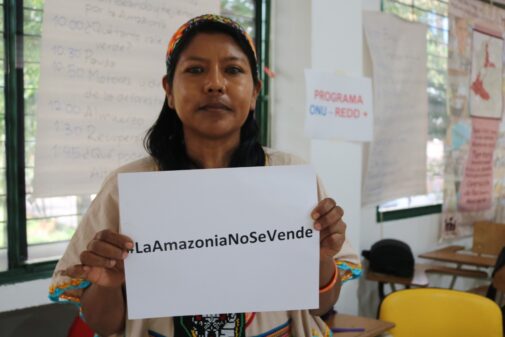 Nasa indigenous woman in Colombia holding a sign