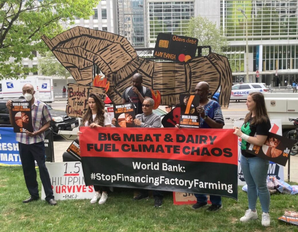 Protesters in Washington DC holding a sign that asks the World Bank to stop funding factory farming