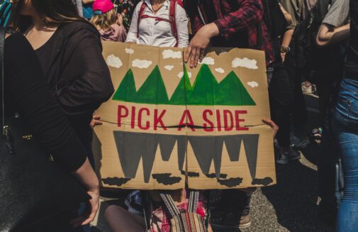 Photo of a sign at "Fridays for Future" that reads "pick a side"