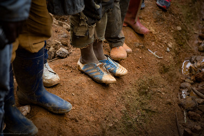 People in Goma DRC standing on eroded soil near a mine